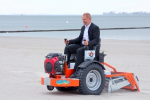 Oberbürgermeister Alexander Badrow überzeugt sich persönlich von der Leistungsfähigkeit der Strandreinigungsmaschine.